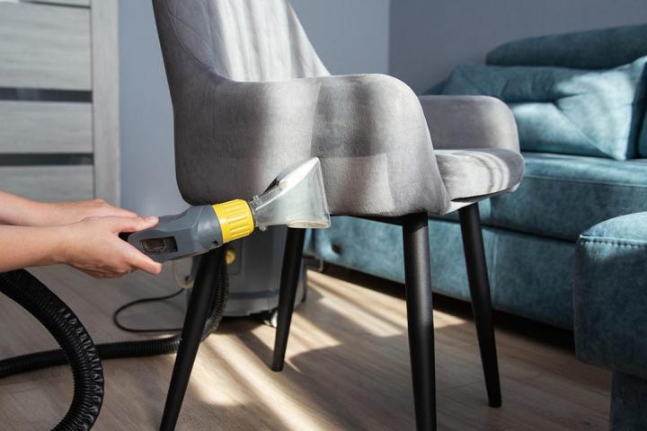 Un limpiador de tapicerías limpiando una silla