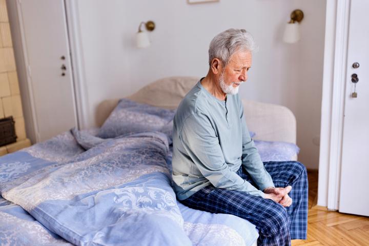 Una persona mayor sentada en su cama, en una imagen de archivo.