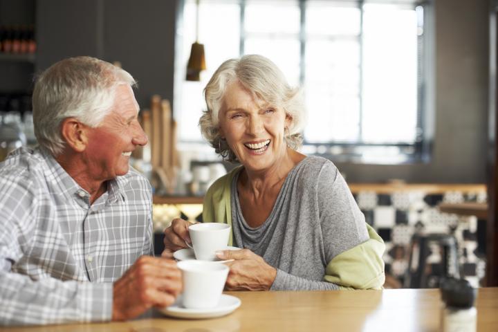Una pareja de personas mayores tomando café en un restaurante.
