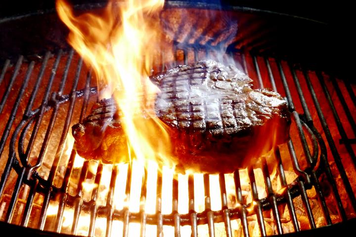 Imagen de archivo de un chuletón cocinándose a la parrilla, en una barbacoa.