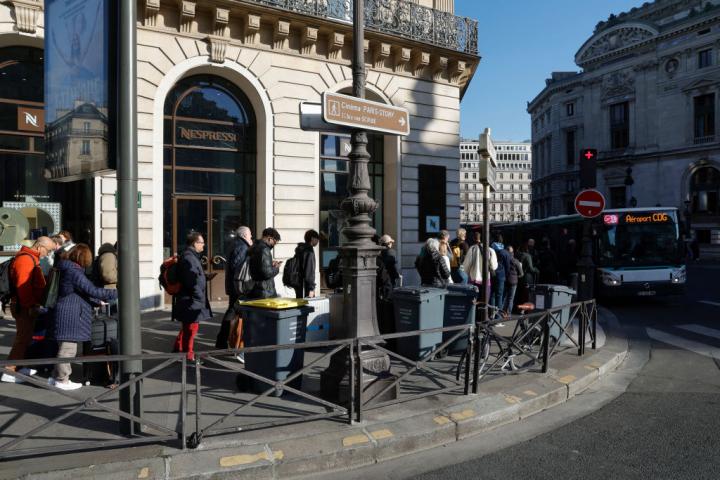 Pasajeros hacen cola para subirse a un autobús en el centro de París