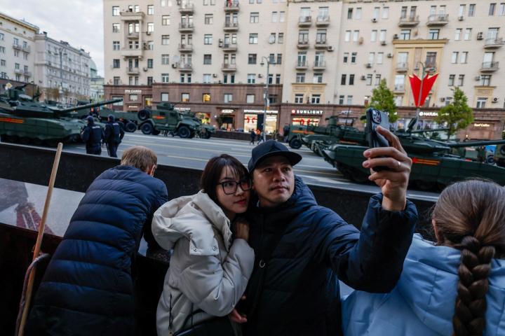 Dos turistas se hacen un selfi durante los ensayos del desfile del Día de la Victoria.