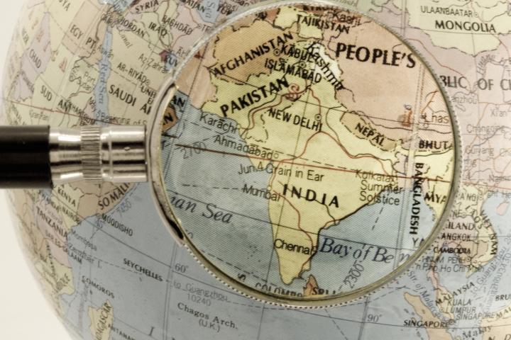 Imagen de un globo terráqueo, con una lupa enfocando a India y Pakistán.