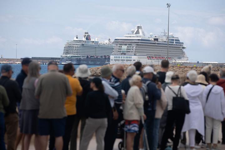 Turistas en el puerto de Palma, con varios cruceros al fondo.