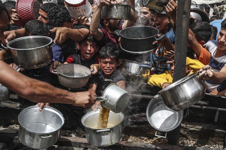 Ciudadanos palestinos se agolpan en un punto de entrega de ayuda humanitaria en Gaza.