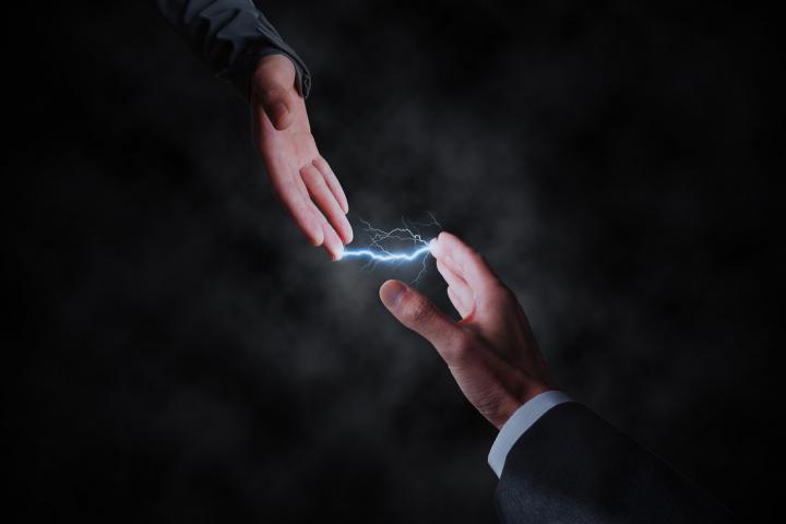 Dos hombres se pasan corriente eléctrica.