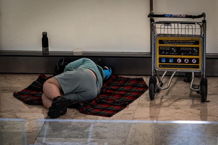 Una persona durmiendo en la T4 del Aeropuerto Adolfo Suárez Madrid-Barajas