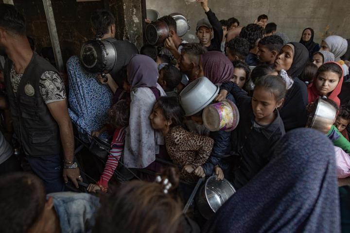 Cientos de palestinos se amontonan frente al Comedor Social Sokar en la Ciudad de Gaza para conseguir raciones limitadas de comida