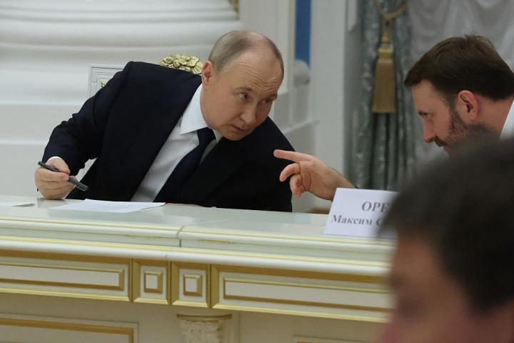 Vladimir Putin, conversando con uno de sus altos cargos durante su reunión con empresarios este lunes