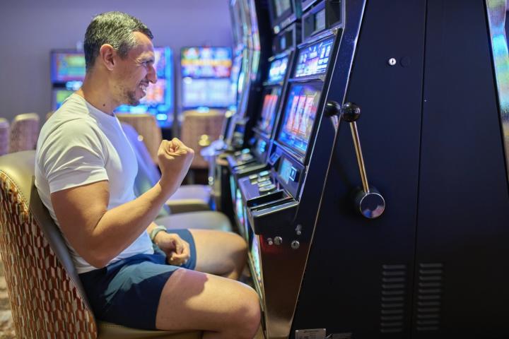 Un hombre celebra haber ganado un premio en un tragaperras.