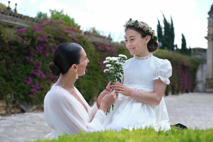 Una madre dándole flores a su hija el día de la comunión