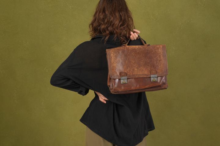 Una joven trabajadora sostiene un maletín con el que va a trabajar.