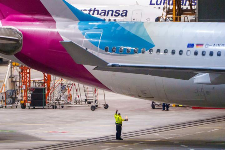 Un operario del aeropuerto gestiona  el estacionamiento de un avión.