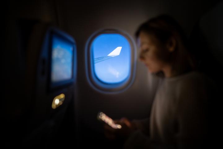 Una mujer usando su móvil en un avión.