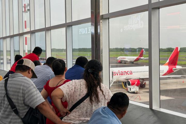 Un grupo de personas observa un avión con migrantes deportados en Estados Unidos.
