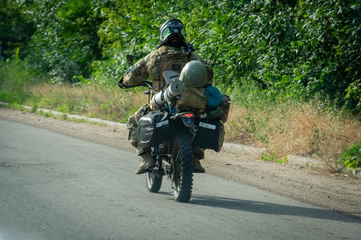 Un soldado ucraniano conduce una motocicleta por una carretera de Ucrania.