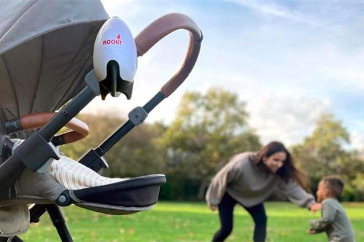 una mujer jugando con su hijo con un carrito en primer plano.