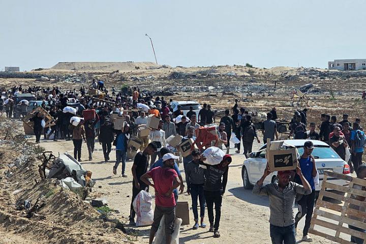 Desplazados palestinos reciben algo de ayuda en las afueras de Rafah, al sur de Gaza