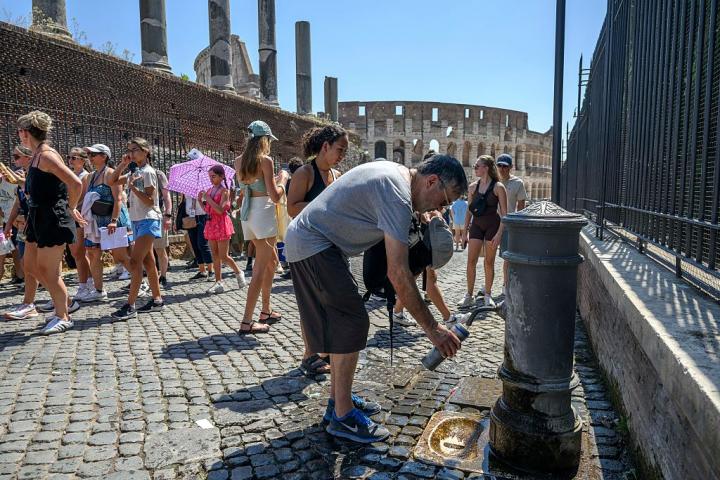 Un gran grupo de turistas, en los alrededores del Coliseo de Roma en plena ola de calor