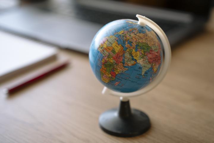 Pequeño globo terráqueo en un escritorio de madera.