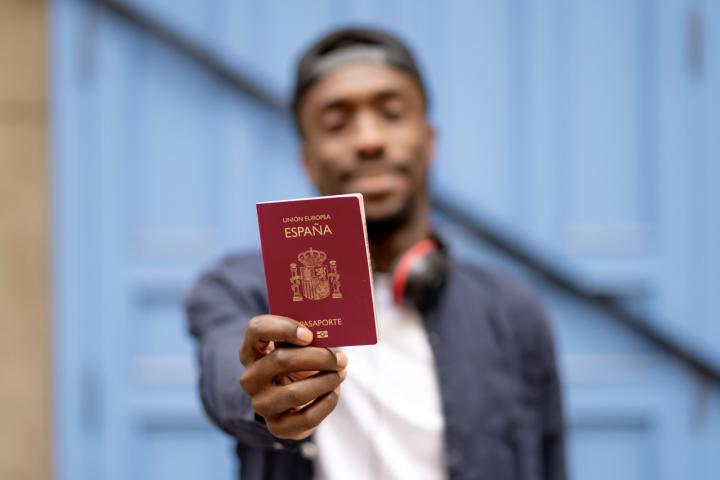 Un hombre sostiene el pasaporte español