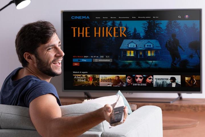 Un chico con el mando del stick viendo la tele en su casa.