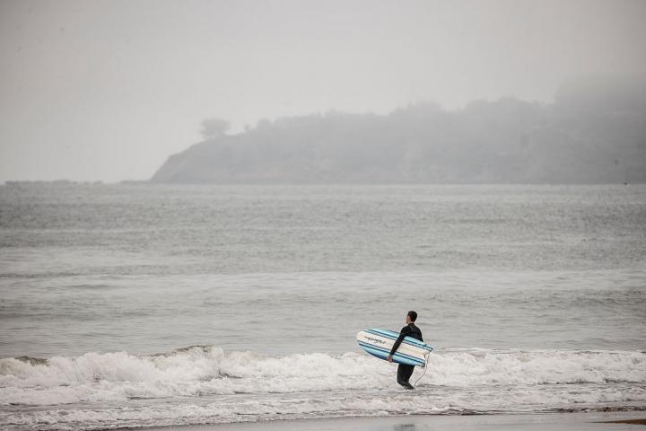Un surfista, a punto de meterse en el agua en Stinson Beach, en California.