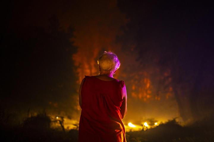 Una vecina ante el incendio forestal que permanece activo en As Neves, Pontevedra.
