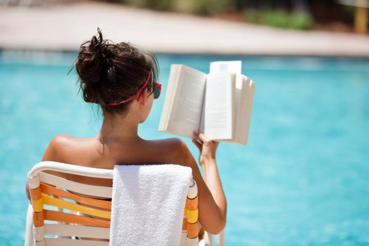 Imagen de archivo de una mujer leyendo en la piscina.