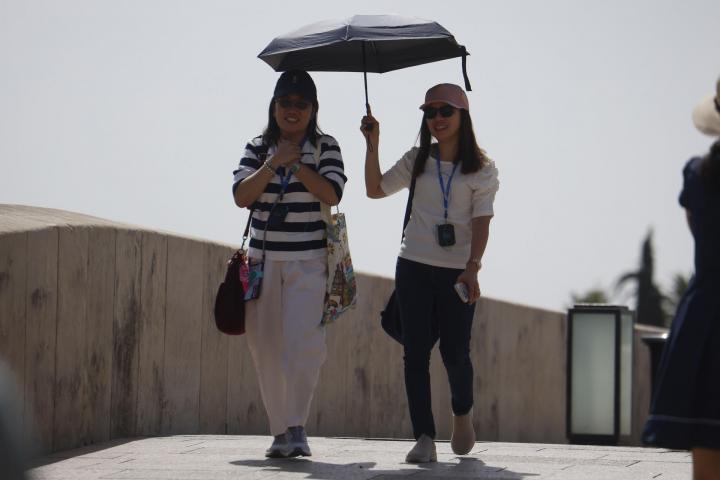 Dos personas se protegen del sol con un paraguas para aliviar las altas temperaturas este domingo en Córdoba.
