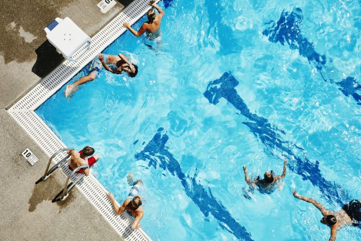 Imagen de archivo de jóvenes disfrutando en una piscina.
