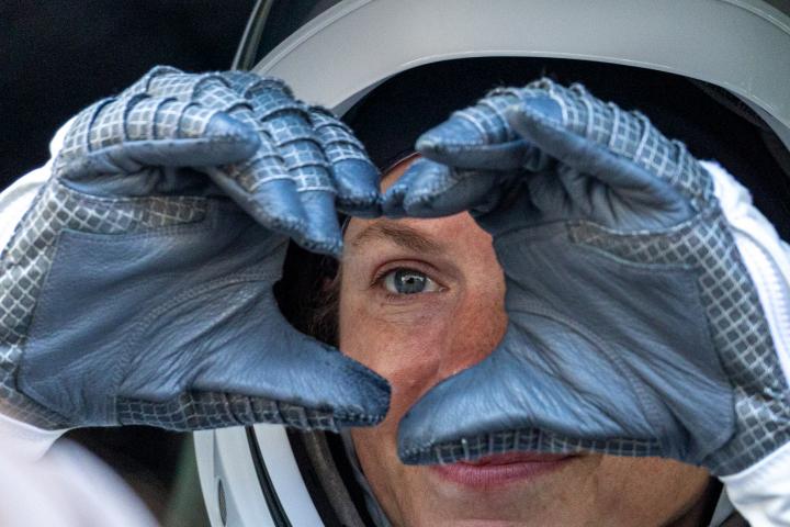 Una astronauta dibuja un corazón con las manos antes de partir hacia la Estación Espacial Internacional (EEI), desde el Kennedy Space Center, en Florida (EEUU).
