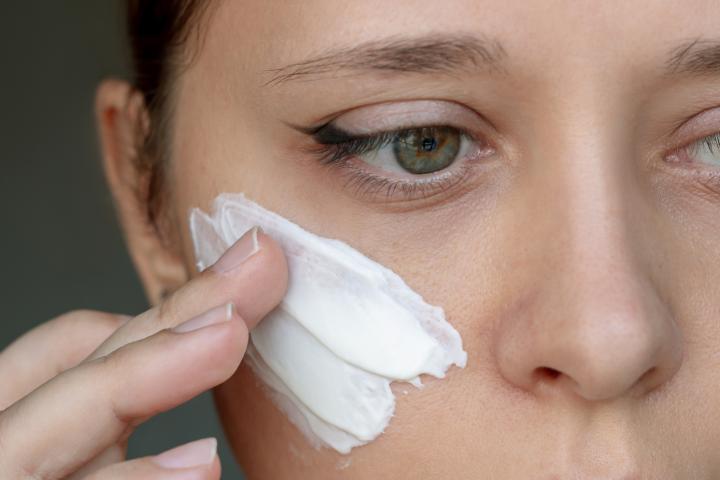 Imagen de archivo de una persona poniéndose crema en el rostro.