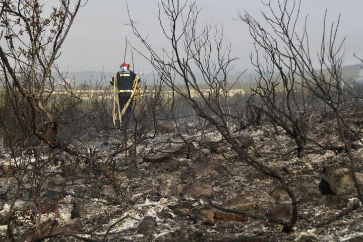 Un bombero recorre una zona calcinada por el incendio forestal que afecta a Puercas (Zamora), en la sierra de la Culebra, este martes
