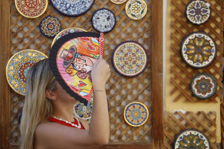 Una turista se cubre la cabeza con un abanico mientras camina por los alrededores de la Mezquita-Catedral de Córdoba el 12 de agosto de 2025.