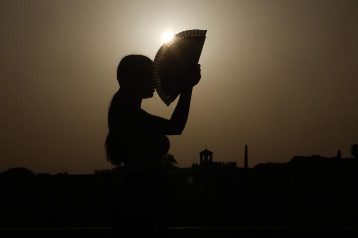 Una persona se abanica al atardecer en una jornada de altas temperaturas en la ciudad de Córdoba.