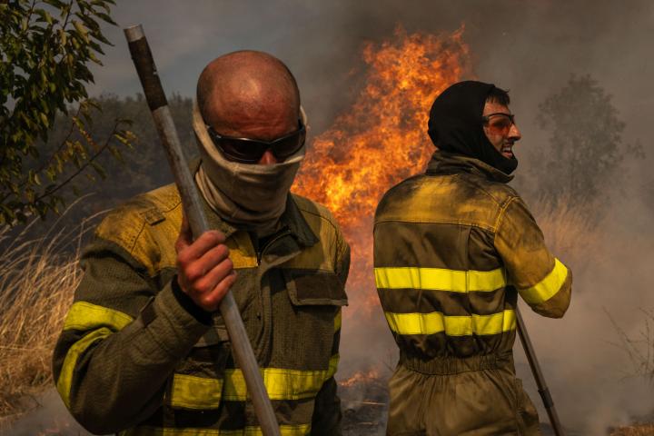 Dos voluntarios realizan labores de extinción en el incendio de Oímbra (Ourense).