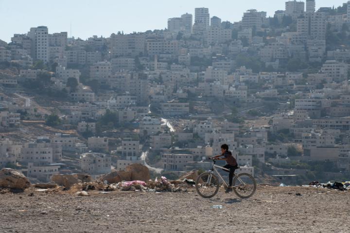 Un niño pedalea en su bicicleta en por el área de Al Eizariya, objetivo de lo planes de construcción israelíes al este de Jerusalén, que romperán la continuidad entre el norte y el sur de Cisjordania y harán aún más difícil la constitución de un Estado palestino.