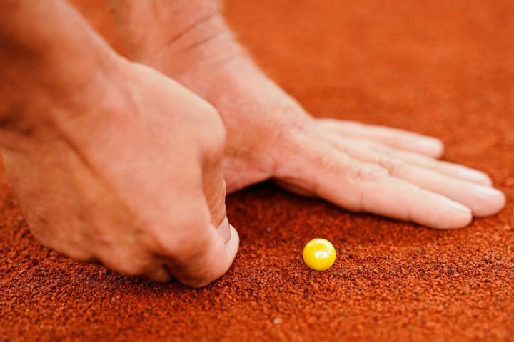 Una persona golpea una canica en un circuito, en una imagen de archivo.