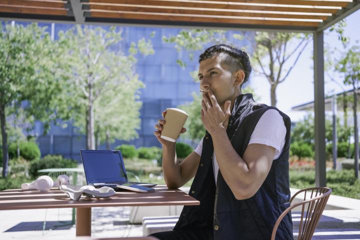Imagen de archivo de un hombre fumando en una terraza.