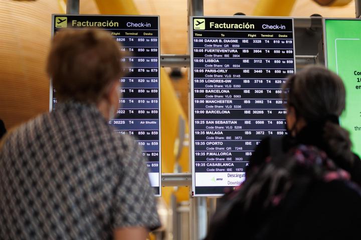 Dos personas viendo viajes en Barajas.