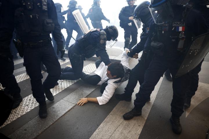Policías detienen a uno de los manifestantes en París