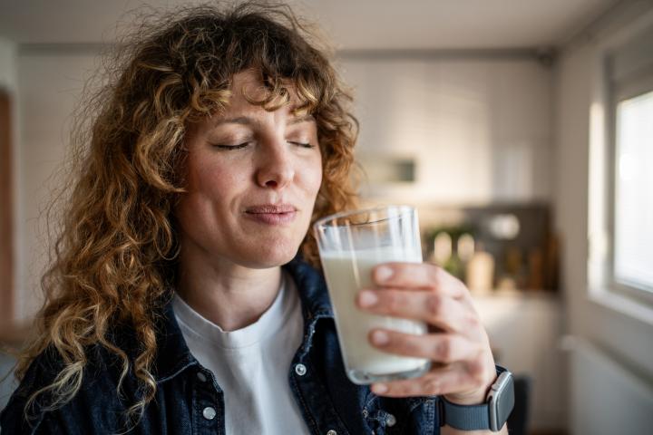 Una mujer disfruta de un vaso de leche.