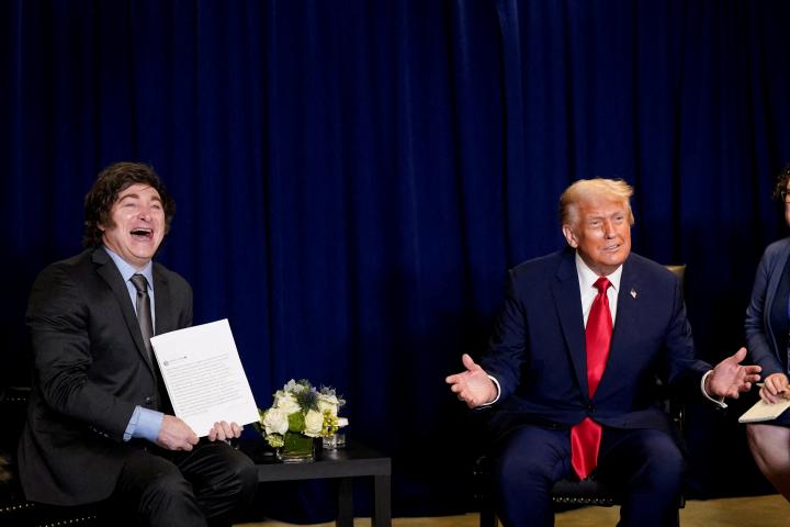 El mandatario argentino, Javier Milei, posa con una fotocopia, con firma dedicada, de una publicación de Donald Trump en Truth Social; acompañado de su propio homólogo estadounidense.