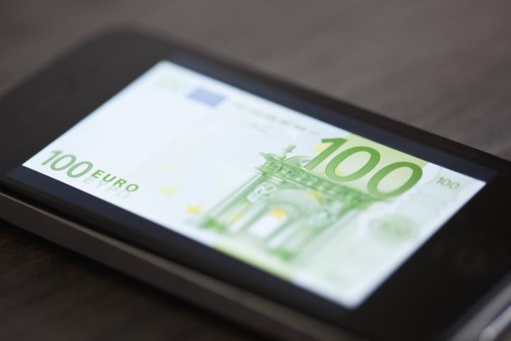 Billete de 100 euros en la pantalla de un smartphone para detectar falsificaciones.