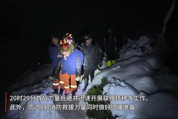 Rescatistas tibetanos trasladan a un excursionista entre la nieve durante la operación de evacuación nocturna en el valle de Gama, Tíbet.