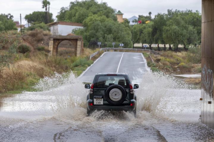 Un coche circula en una zona llena de agua en Cartagena (Murcia).