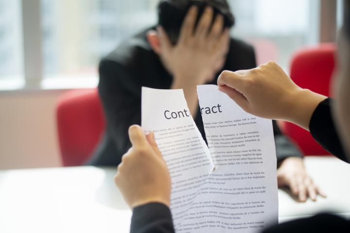Una persona rompiendo un contrato, en una imagen de archivo