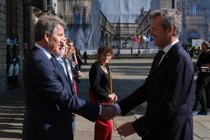 El presidente nacional del PP, Alberto Núñez Feijóo; saludando al presidente de la Xunta, Alfonso Rueda (PPdeG); con la alcaldesa de Santiago de Compostela observando de fondo, Goretti Sanmartín (BNG).