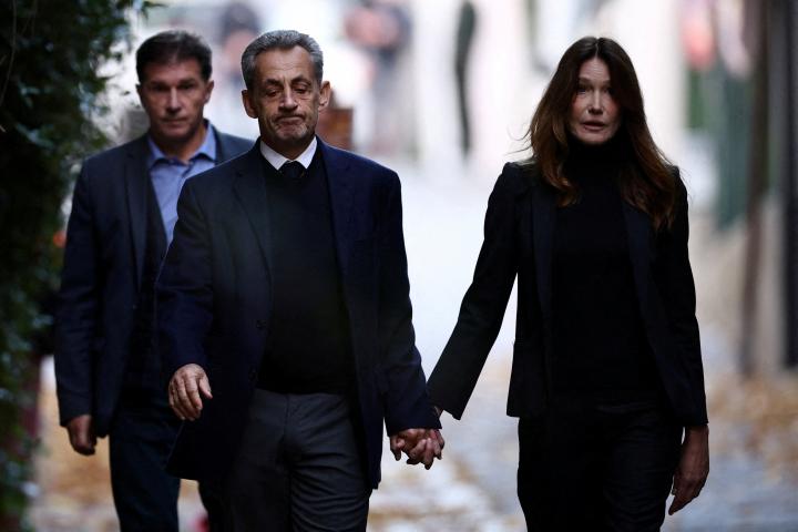 Nicolas Sarkozy y Carla Bruni salen de su casa de la mano, vestidos de negro, antes de que él se marche para entrar en prisión.